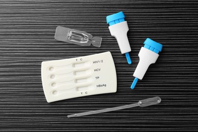 Photo of Disposable multi-infection express test kit on black wooden table, flat lay