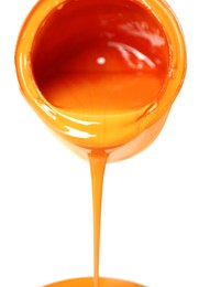 Photo of Pouring orange paint from can on white background, closeup