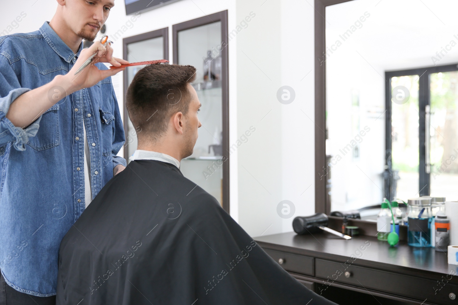 Photo of Professional barber working with client in hairdressing salon. Hipster fashion