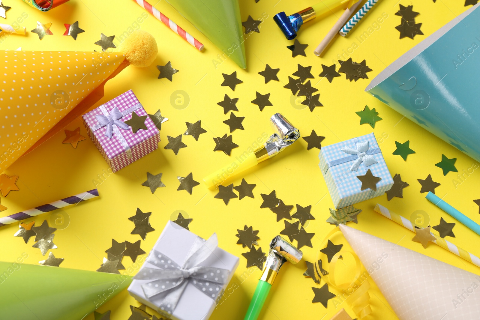 Photo of Flat lay composition with party hats on yellow background