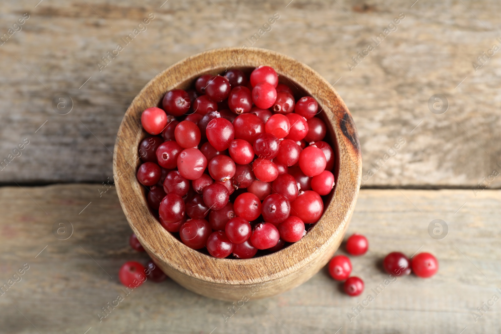 Photo of Cranberries in bowl on wooden table, above view