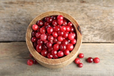 Photo of Cranberries in bowl on wooden table, above view