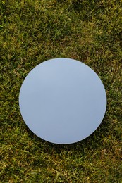 Photo of Spring atmosphere. Round mirror on grass reflecting sky, top view