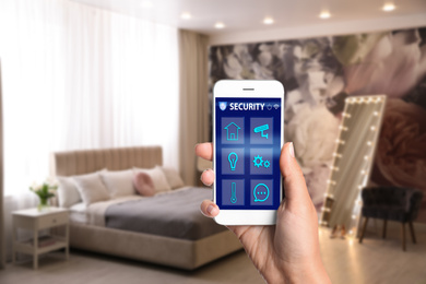Image of Woman using home security app indoors, closeup