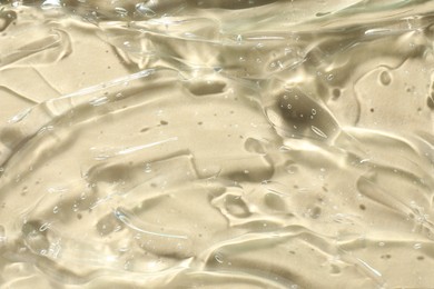 Photo of Clear cosmetic gel on beige background, closeup