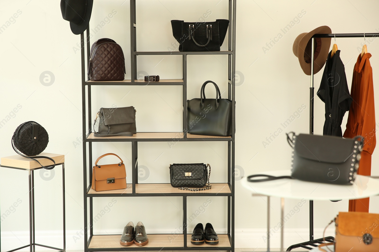 Photo of Stylish woman's bags on shelves in boutique