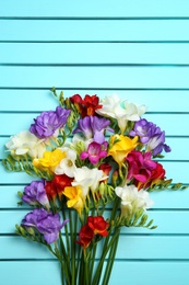 Photo of Beautiful freesia flowers on wooden background