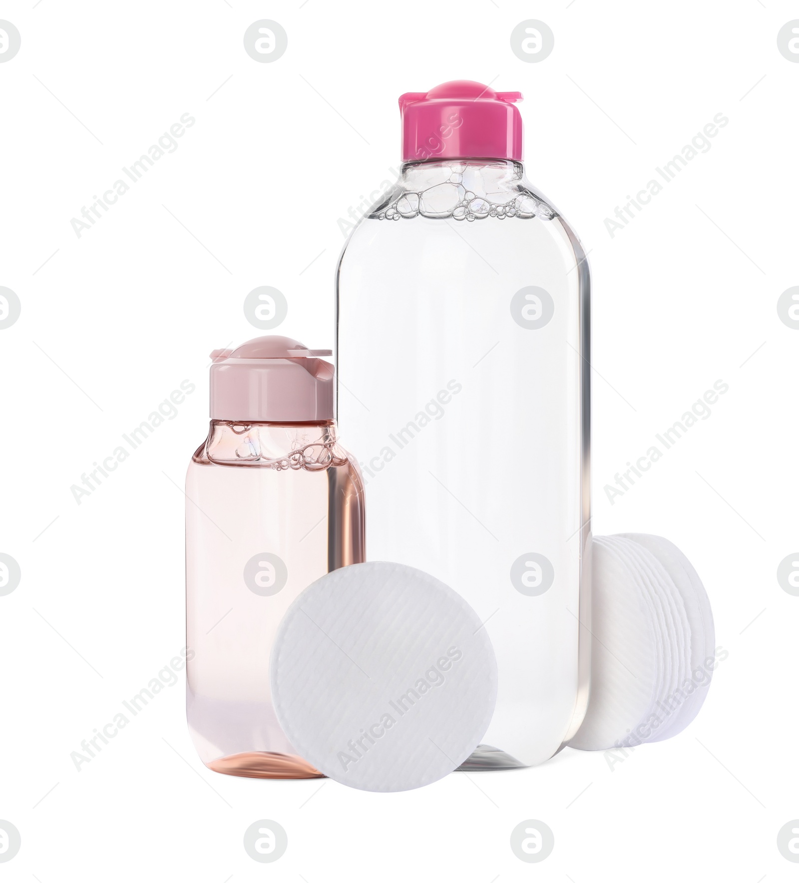 Photo of Bottles of micellar cleansing water and cotton pads on white background