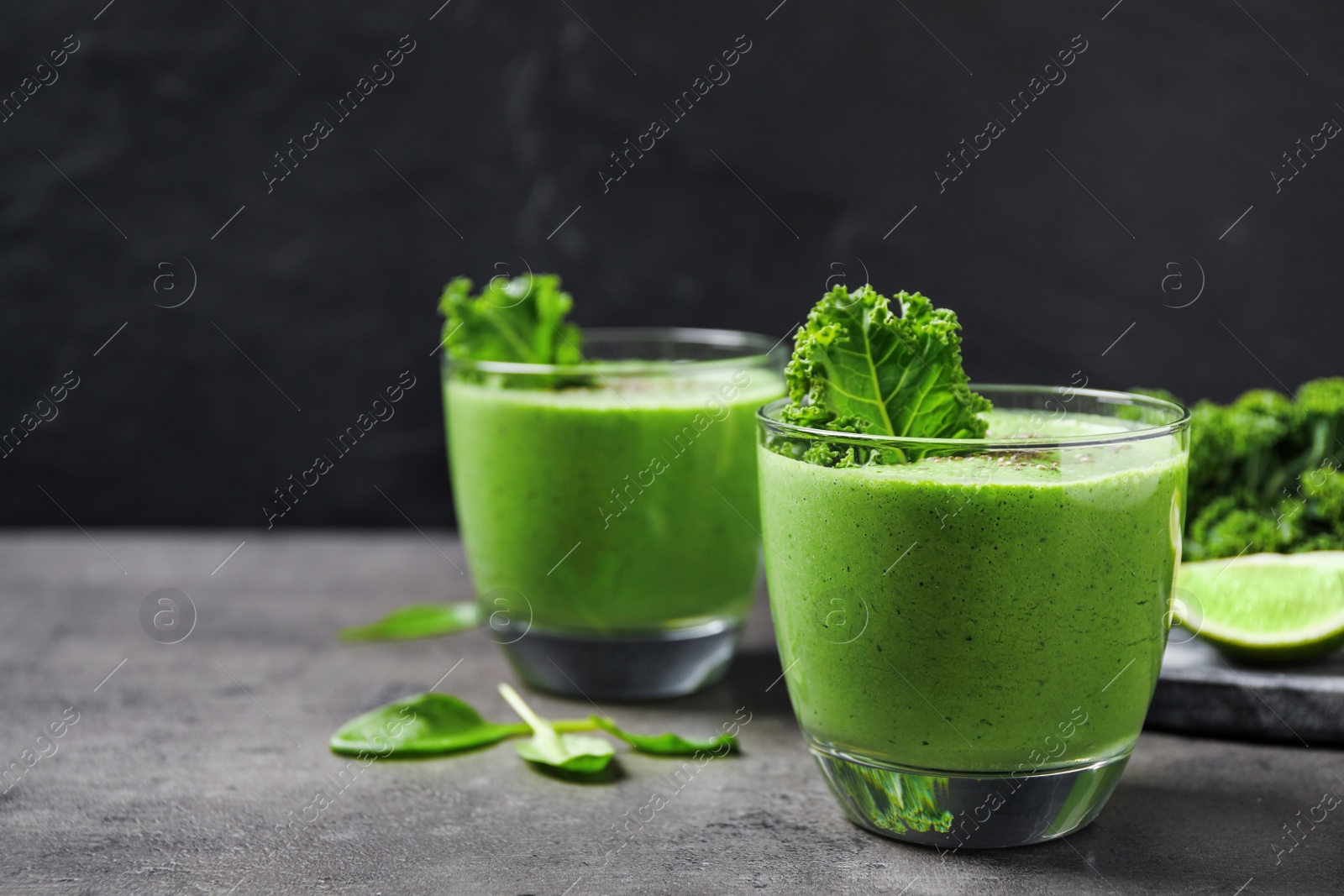 Photo of Tasty kale smoothie on grey table, closeup