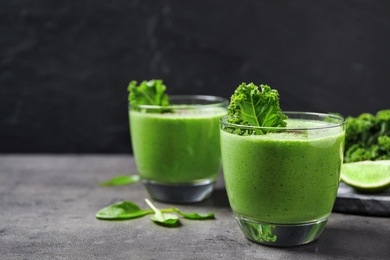 Photo of Tasty kale smoothie on grey table, closeup