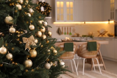 Photo of Beautiful Christmas tree in spacious kitchen, closeup. Space for text