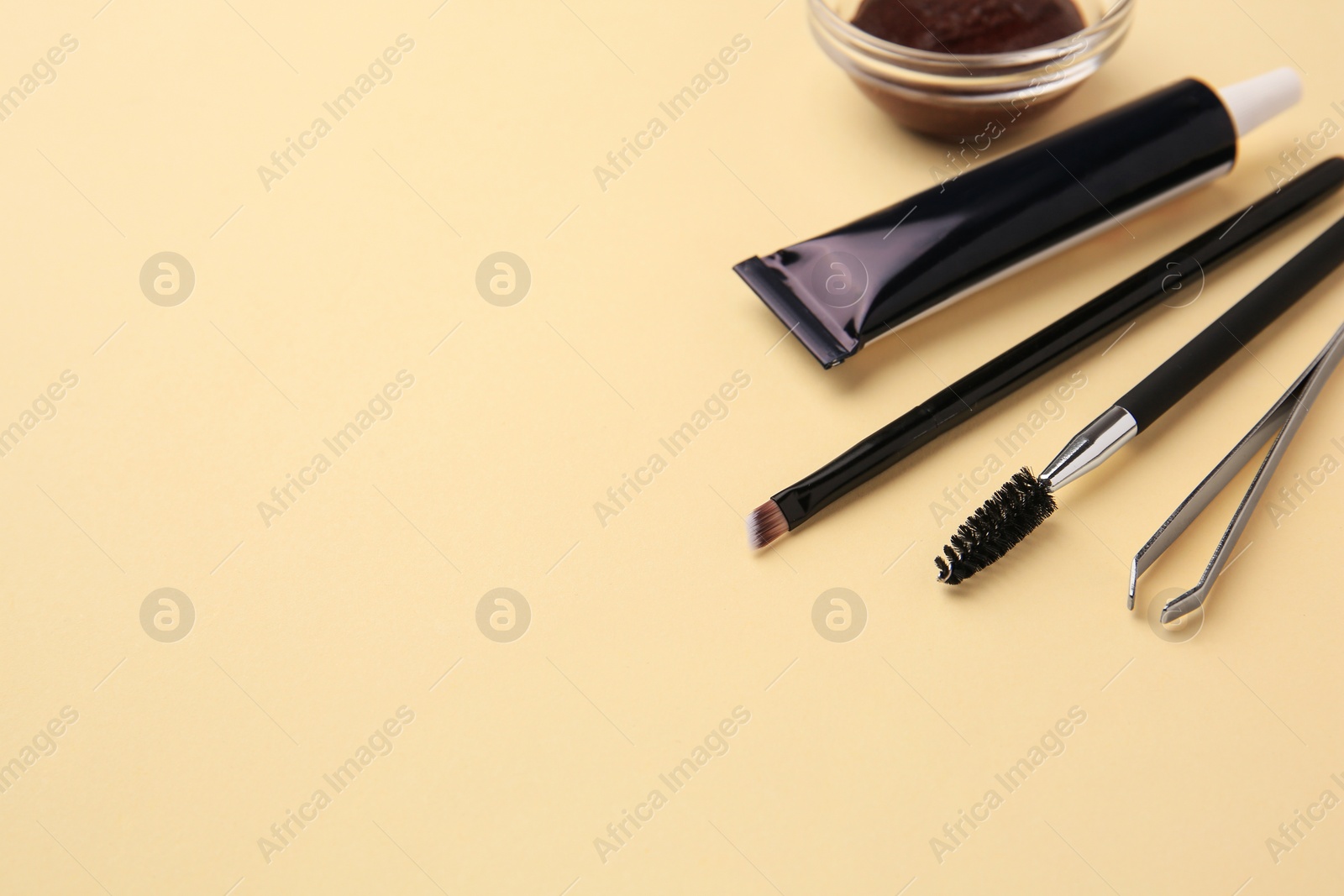 Photo of Eyebrow henna and tools on beige background. Space for text