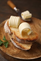 Photo of Tasty butter curls and slices of bread on wooden table, closeup