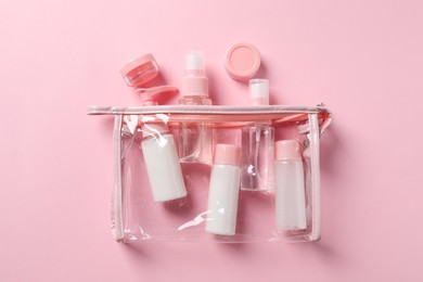 Plastic bag with cosmetic travel kit on pink background, flat lay. Bath accessories