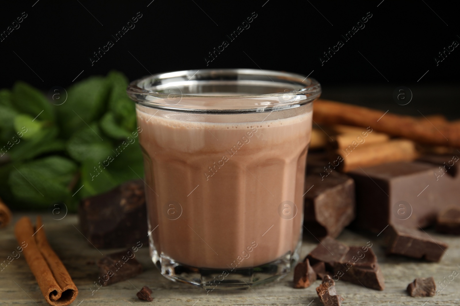 Photo of Glass of delicious hot cocoa on wooden table