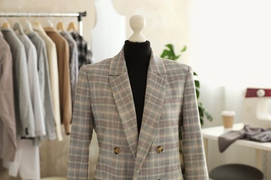 Photo of Mannequin with stylish jacket in tailor shop