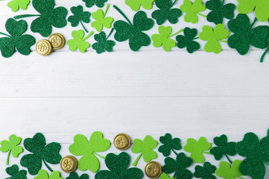 Frame made of clover leaves on white wooden table, flat lay with space for text. St. Patrick's Day celebration