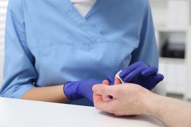 Photo of Laboratory testing. Doctor taking blood sample from patient at white table in hospital, closeup