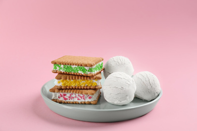 Sweet delicious ice cream cookie sandwiches on pink background