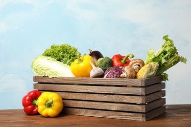 Photo of Fresh vegetables and crate on wooden table