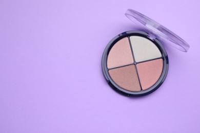 Photo of Colorful contouring palette on violet background, top view with space for text. Professional cosmetic product