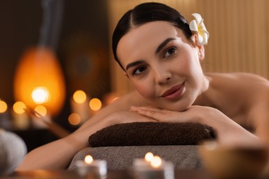 Photo of Spa therapy. Beautiful young woman lying on massage table in salon