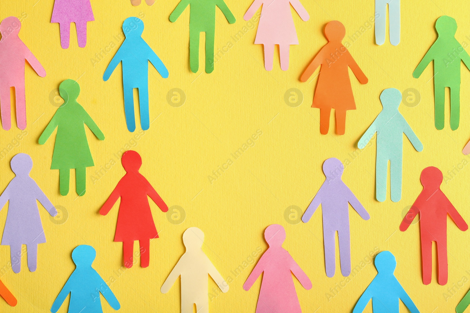 Photo of Frame of different paper human figures on yellow background, flat lay with space for text. Diversity and inclusion concept