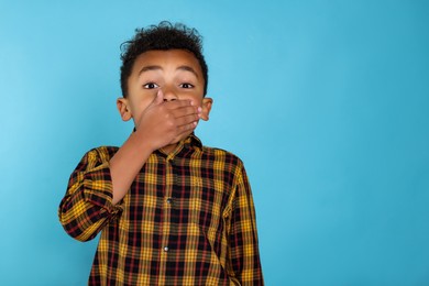Photo of Emotional African-American boy on turquoise background. Space for text