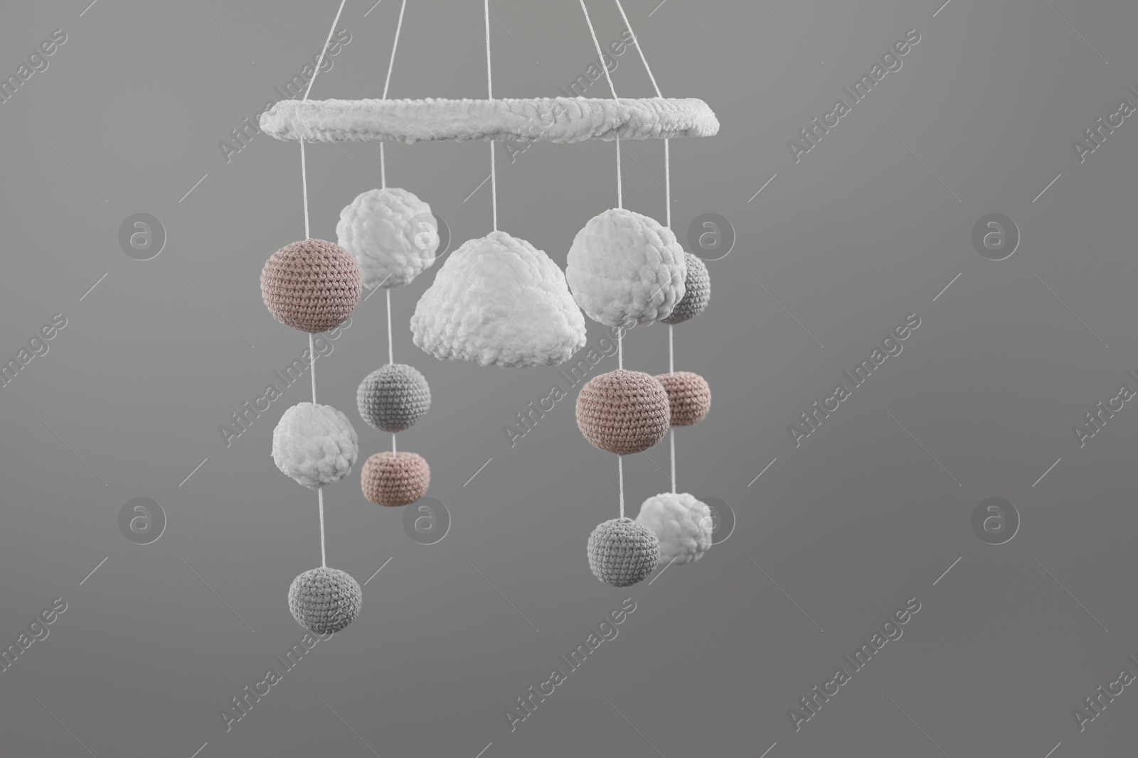 Photo of Cute baby crib mobile on grey background. Space for text