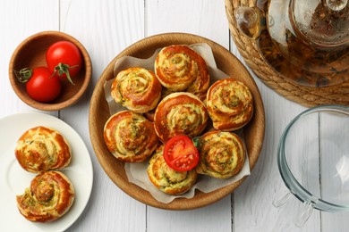 Photo of Fresh delicious puff pastry served with tea and tomatoes on white wooden table, flat lay