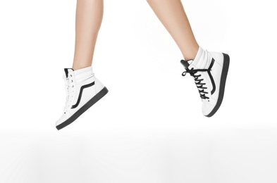 Woman in stylish shoes jumping on white background, closeup