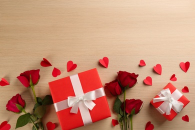 Photo of Flat lay composition with gift boxes on wooden table, space for text. Valentine's Day celebration