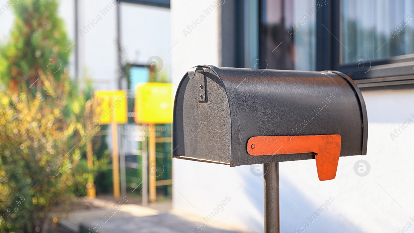 Photo of Black mailbox near house outdoors on sunny day