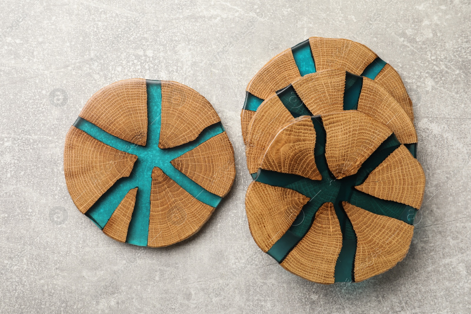 Photo of Stylish wooden cup coasters on light grey table, flat lay