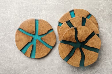 Stylish wooden cup coasters on light grey table, flat lay
