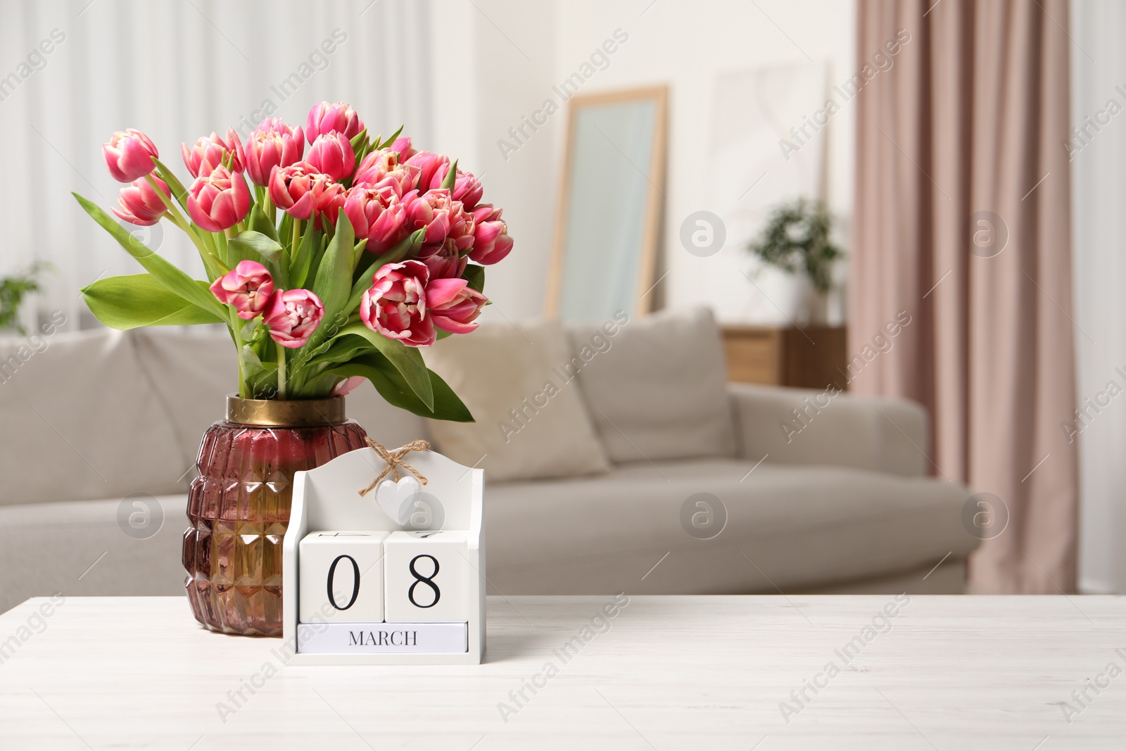 Photo of International Women's day - 8th of March. Block calendar and bouquet of beautiful tulips on white wooden table. Space for text