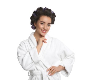 Photo of Happy young woman in bathrobe with hair curlers on white background