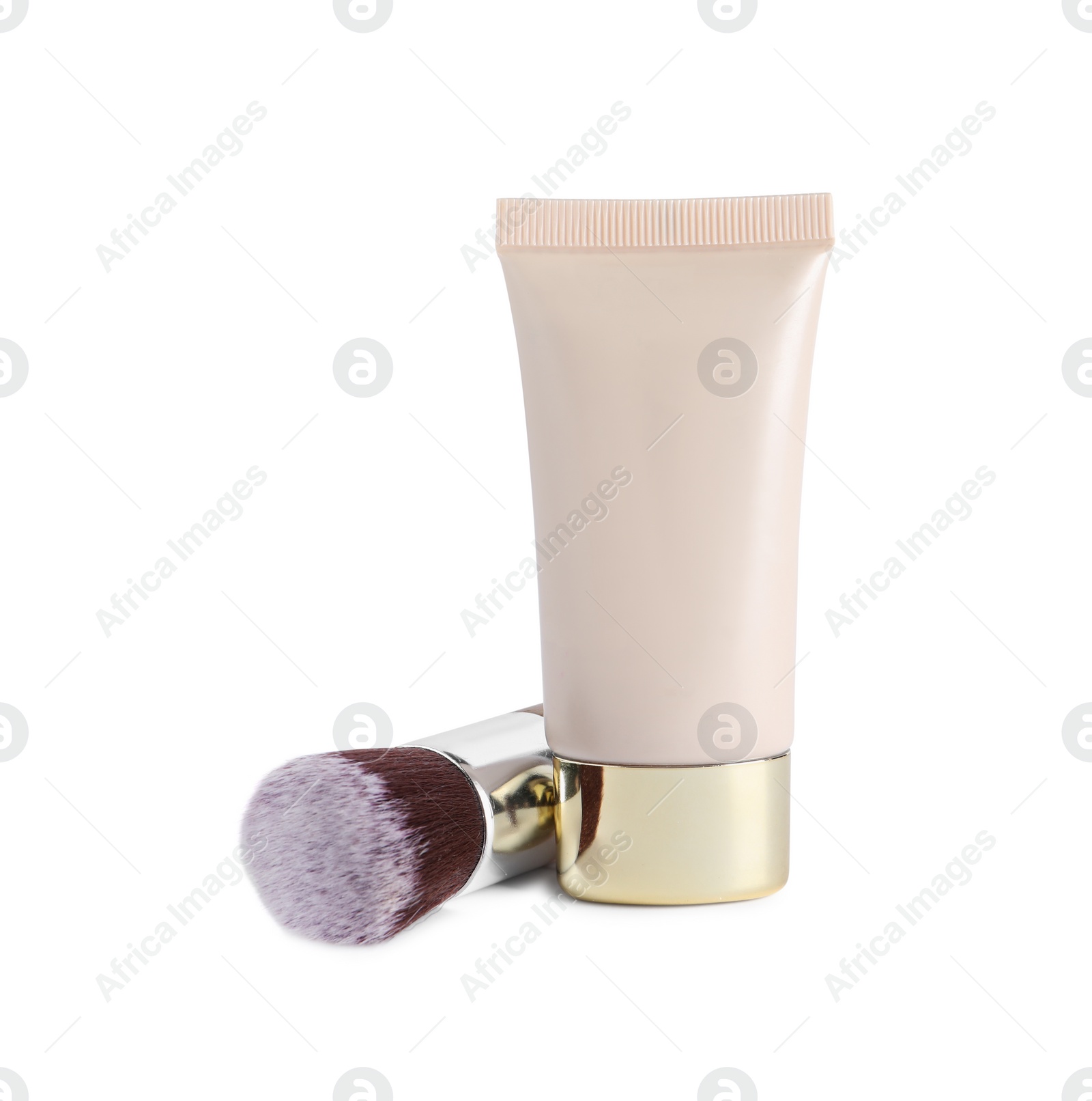 Photo of Tube of skin foundation and brush on white background. Makeup product