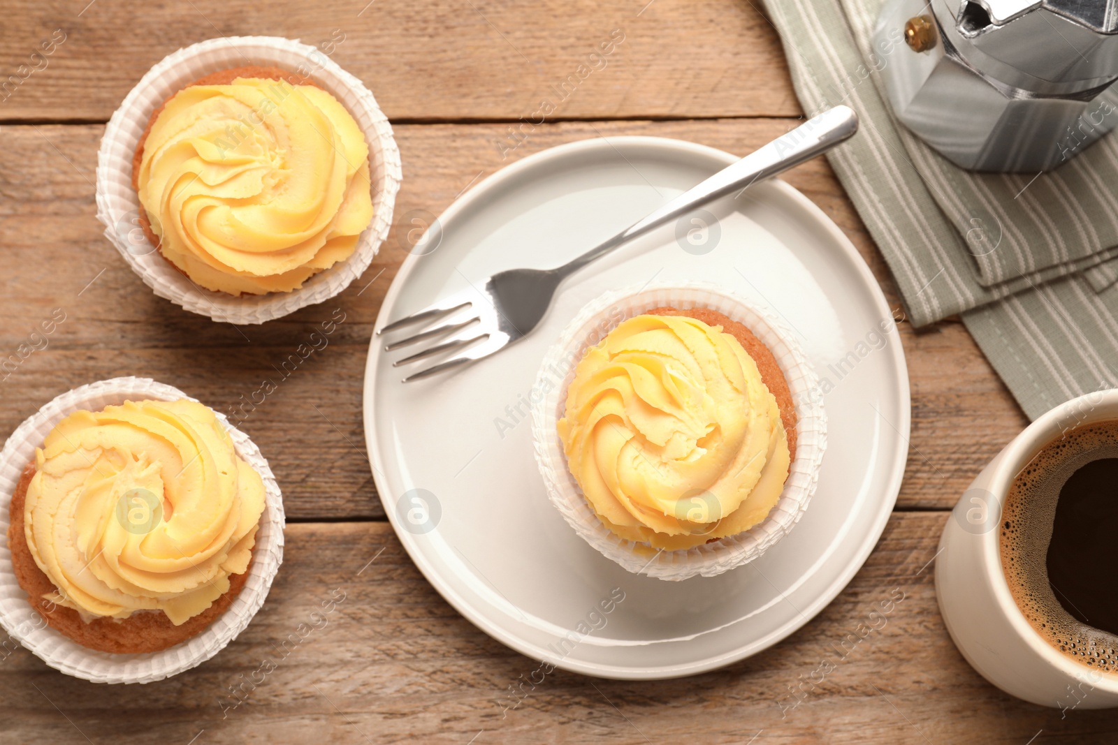 Photo of Tasty cupcakes served on wooden table, flat lay