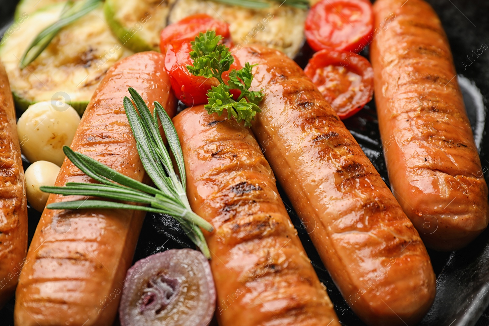 Photo of Delicious sausages with vegetables on grill pan, closeup. Barbecue food