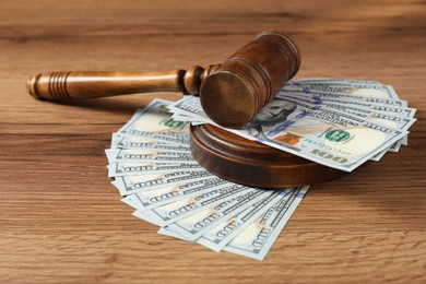 Judge's gavel and money on wooden table