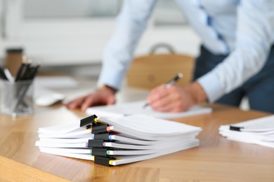 Photo of Businessman working at wooden table in office, focus on documents
