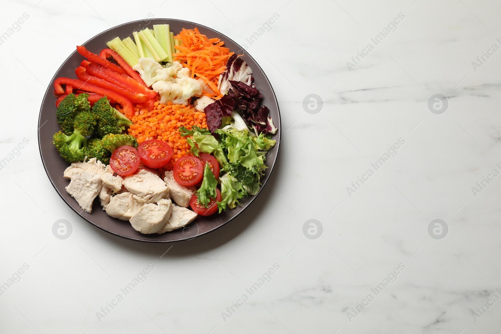 Photo of Balanced diet and healthy foods. Plate with different delicious products on white marble table, top view. Space for text