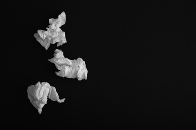 Photo of Used paper tissues on black background, flat lay. Space for text