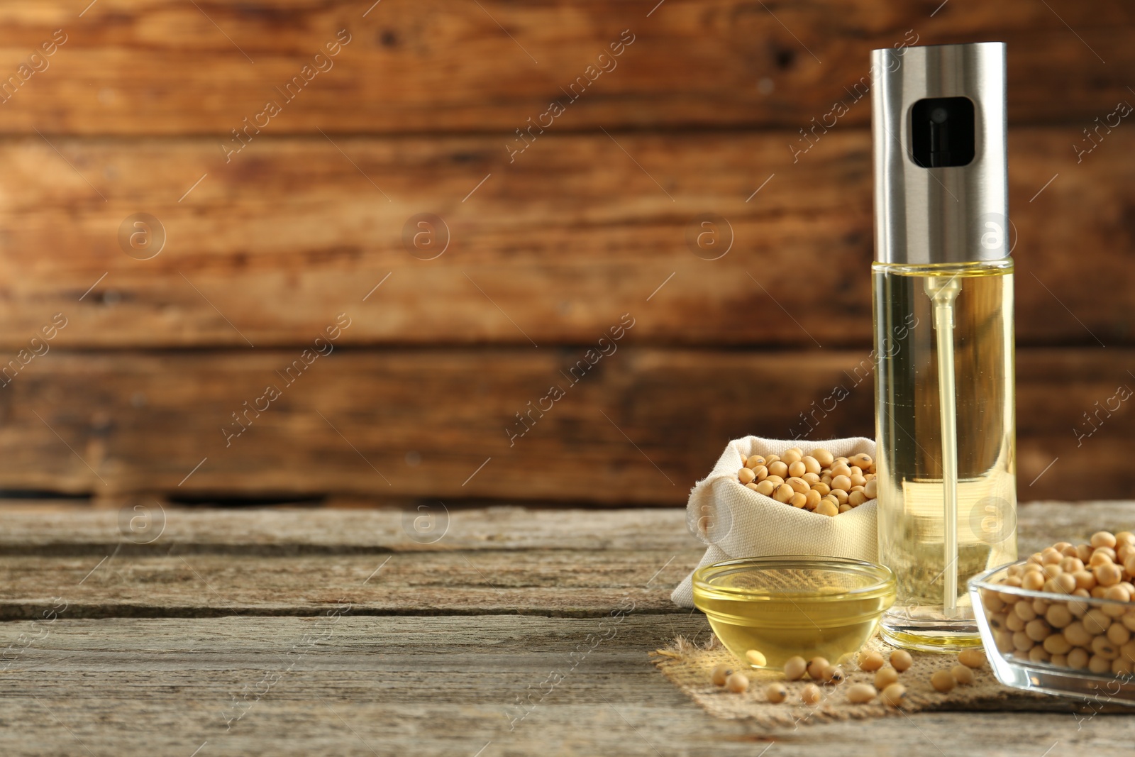 Photo of Composition with soybean oil on wooden table. Space for text