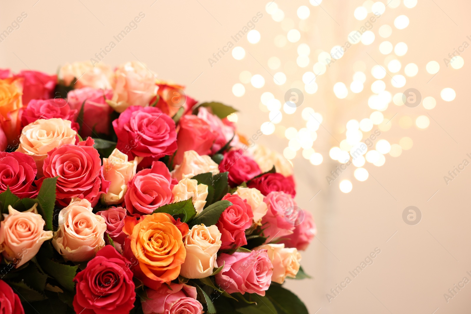 Photo of Beautiful bouquet of colorful roses on beige background, space for text