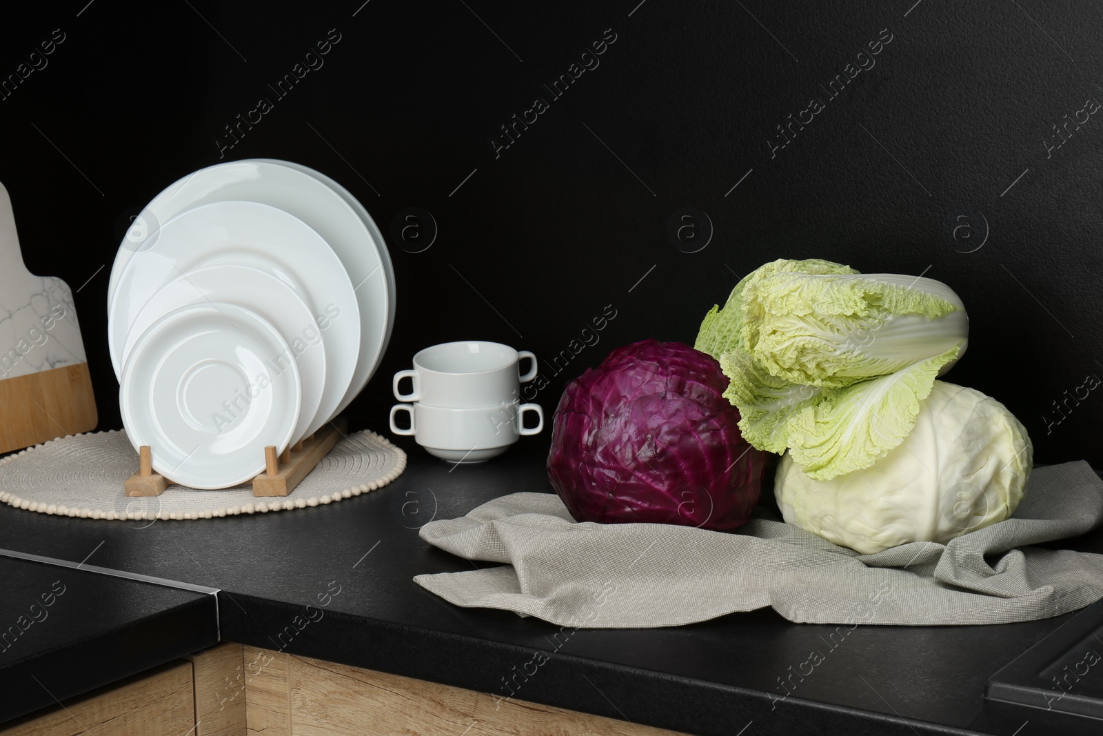 Photo of Different types of cabbage on countertop in kitchen