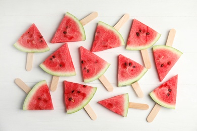 Photo of Slices of ripe watermelon on white wooden table, flat lay