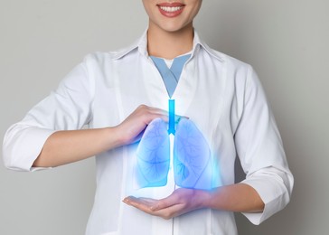 Image of Doctor demonstrating digital image of human lungs on light background, closeup