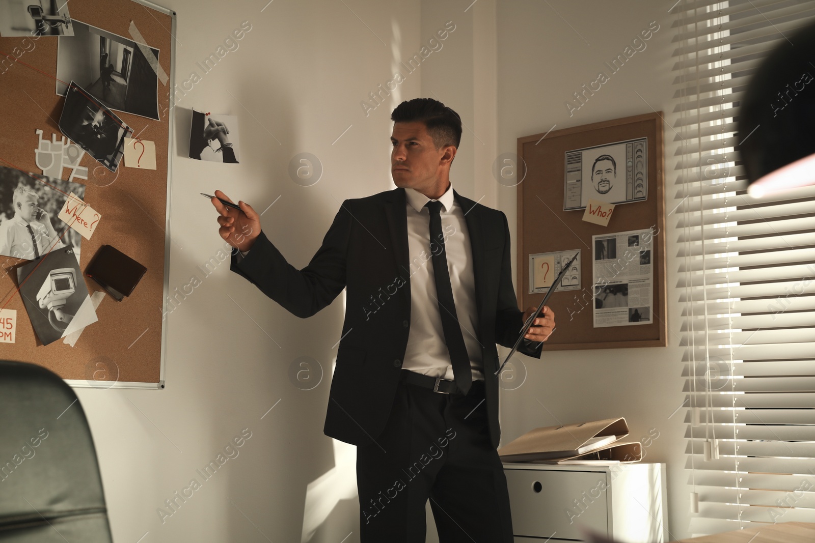 Photo of Detective looking at evidence board in office